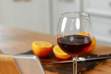 Glass of red wine and oranges on kitchen counter