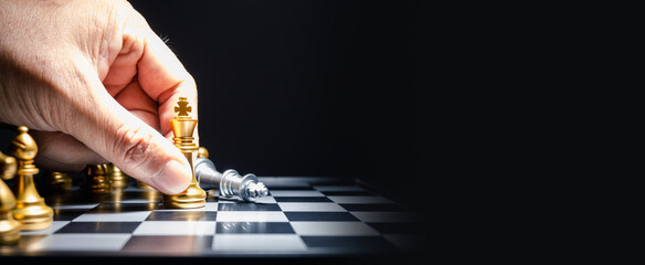 Human hand moving king chess piece at table
