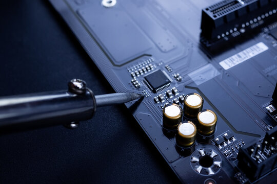 Repairman Is Soldering The Motherboard Of Electronic Device