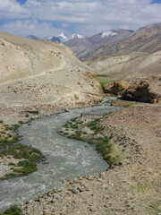 Mountain torrent and footbridge on the Afghan side of the Pamir river in Wakhan Corridor high-altitude desert between Langar and Khargush pass, Gorno-Badakshan, Tajikistan