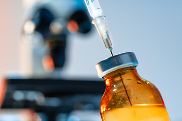 Vaccine bottle with a syringe taking the vaccine from it