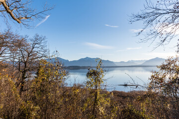 Chiemsee Ufer im Winter mit Bergblick , blauem Himmel und einzelnen Wolken