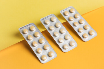 Packs of pills isolated. Yellow pills in medical packaging. Yellow and white blank background 