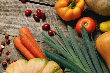 Pile of pumpkins, carrots and leek on table