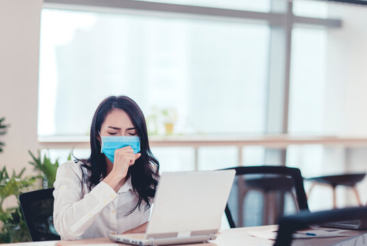 Stressed Young business woman wear face mask and  coughing in office