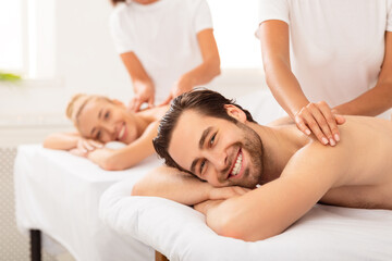 Fototapeta na wymiar Boyfriend And Girlfriend Lying Enjoying Relaxing Massage At Spa Resort