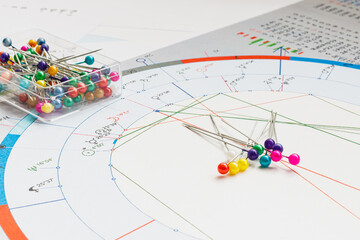Workplace of a modern astrologer. Scattered on the table are printouts of astrological charts,...