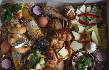 top view breakfast box with croisants, cheese variations, bread rolls, lye pastry, tomato mozzarella. Vegetarian - obrazy, fototapety, plakaty