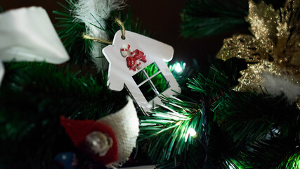 The Christmas tree branch decorated with a house and a ball is filmed close to the new year and Christmas