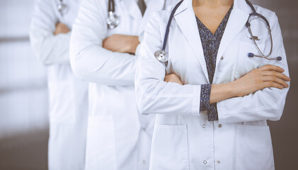 Doctors standing as a team with arms crossed in clinic. Medical help, insurance and medicine concept