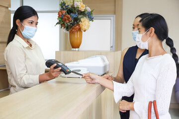 Patient wear face mask and payment by credit card and talking with doctor or nurse in hospital, healthcare treatment process and covid-19 pandemic concept