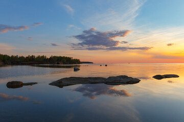 Beatiful sunset over the sea shores with stones. Long exposure, smoothed water