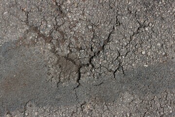 Discolored and cracked asphalt on the road


