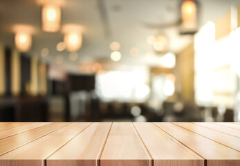 Empty wooden table top with lights bokeh on blur restaurant background.