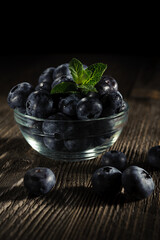 A vase of blueberries on the table.