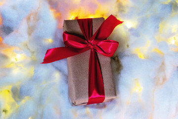 gift box with a red bow on a glowing snow background. christmas and new year concept