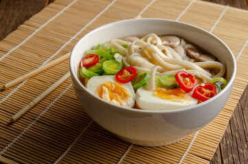 Japanese ramen soup egg, mushrooms and onion on wooden