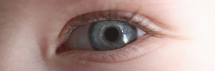Young girl's eye with blue pupil. Childhood vision examination concept
