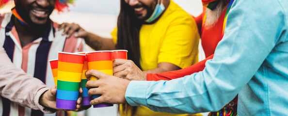 Happy multiracial people cheering and drinking cocktails in gay pride festival event during corona...