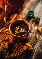 herbal tea. pie and herbal tea in an orange mug on a wooden table. berries, herbs, flowers and tea on a brown wooden table. autumn still life with herbs, delicious pie and flowers on the kitchen table