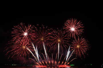 Obraz premium Colorful fireworks display over water at night