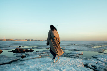 Вeautiful girl in raincoat, winter Gulf of Finland.