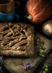 still life with bread. tea with herbs. still life with pumpkin. pie and herbal tea in an orange mug on a wooden table. berries, vegetables, flowers and tea on a brown wooden table