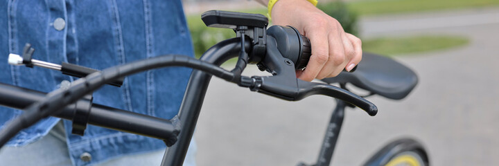Bicyclist holds yellow Bicycle behind wheel. Bicycle rental and rental concept
