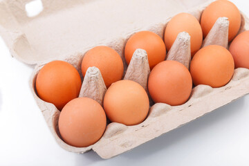 Chicken brown eggs closeup top view On white background. A carton crate of fresh brown eggs.