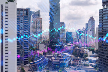 Forex and stock market chart hologram over panorama city view of Bangkok, the financial center in Asia. The concept of international trading. Double exposure.