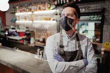 restaurant employee wearing a protective mask against the covid pandemic virus cafe bistro. the...