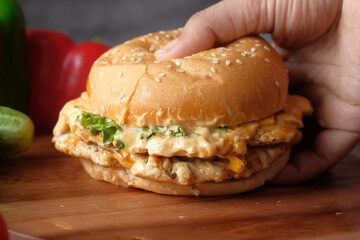 hand holding beef burger on table close up 