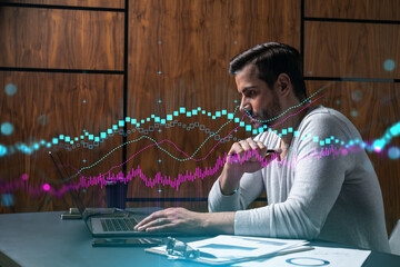 A serious caucasian analyst in casual wears, using laptop to proceed the forecast of stock market...