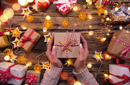 Top View of Woman Hands with Gift Box on Wooden Table.
