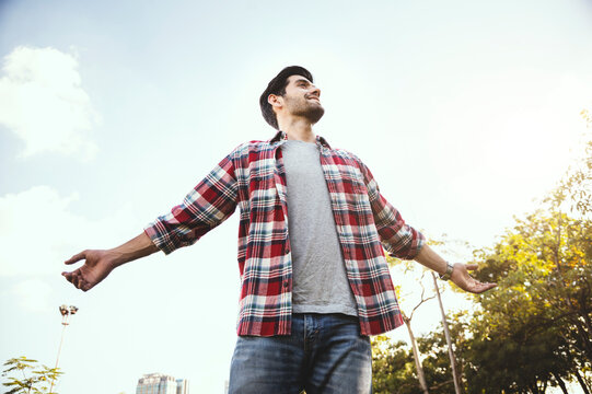 Caucasian Man Standing Raised His Hand In The Park To Breathe Pure Air, Freedom, Holiday.