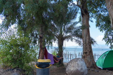 View of Sea of Galilee against the background of the Golan Heights in Israel. Camping on the shores of the Sea of Galilee. Red tent. Cloudy Blue Sky. High quality photo