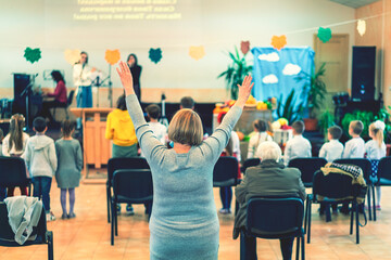 People praying in a church. soft focus of christian people group raise hands up worship God Jesus Christ together in church. toned