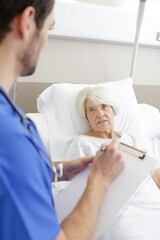 male doctor taking care senior woman in hospital