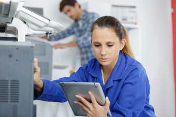 technician holding tablet while working on electrical appliance