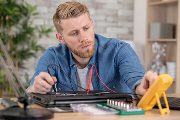 technician man using multimeter to measure the voltage of hd-drive