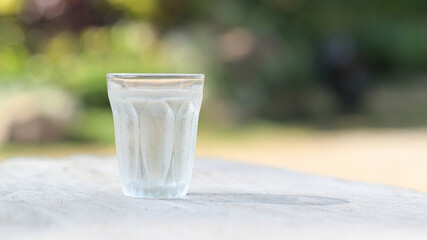 A glass of cold water placed on a wooden table.