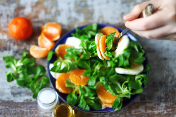 Selective focus. Male hands with a plate of salad at the table. Healthly food. Healthy salad.