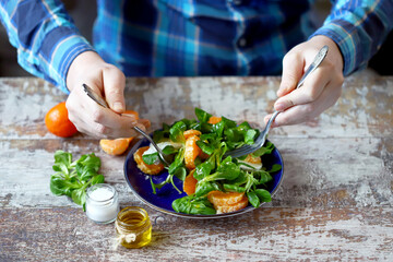 Selective focus. Male hands with a plate of salad at the table. Healthly food. Healthy salad.