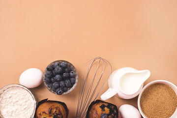 Ingredients for Baking Muffins or Cup Cakes Baking Dish Milk Eggs Sugar Flour Light Brown Background Top View Horizontal Copy Space