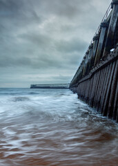 Blyth Pier and harbour mouth on an overcast, grey, winter morning.