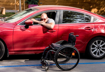 Young handicapped man on driver's seat of his car