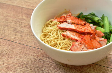 Chinese yellow egg noodles topping slice barbecue pork and boiled cabbage dressing sweet red gravy sauce on bowl