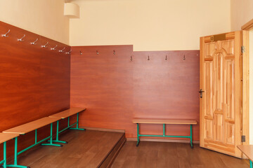 School locker room with benches and hangers. Locker room at a dance school