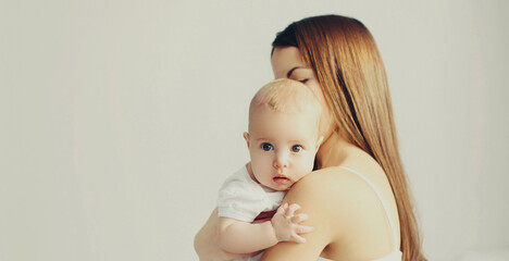 Portrait of happy mother holding her cute baby at home