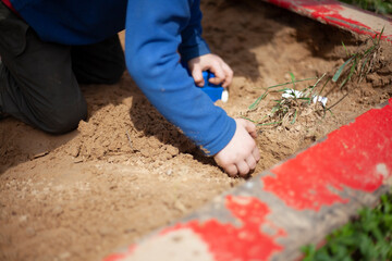 The child plays in the sandbox. Children's entertainment in the yard. 